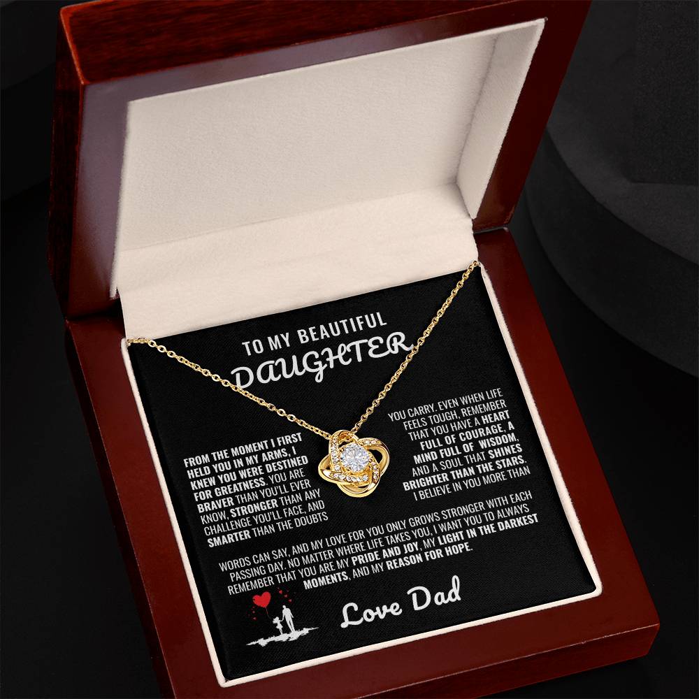 Elegant silver love knot necklace with a sparkling crystal, displayed in a black gift box featuring a heartfelt message from a father to his daughter.