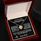 Elegant silver love knot necklace with a sparkling crystal, displayed in a black gift box featuring a heartfelt message from a father to his daughter.