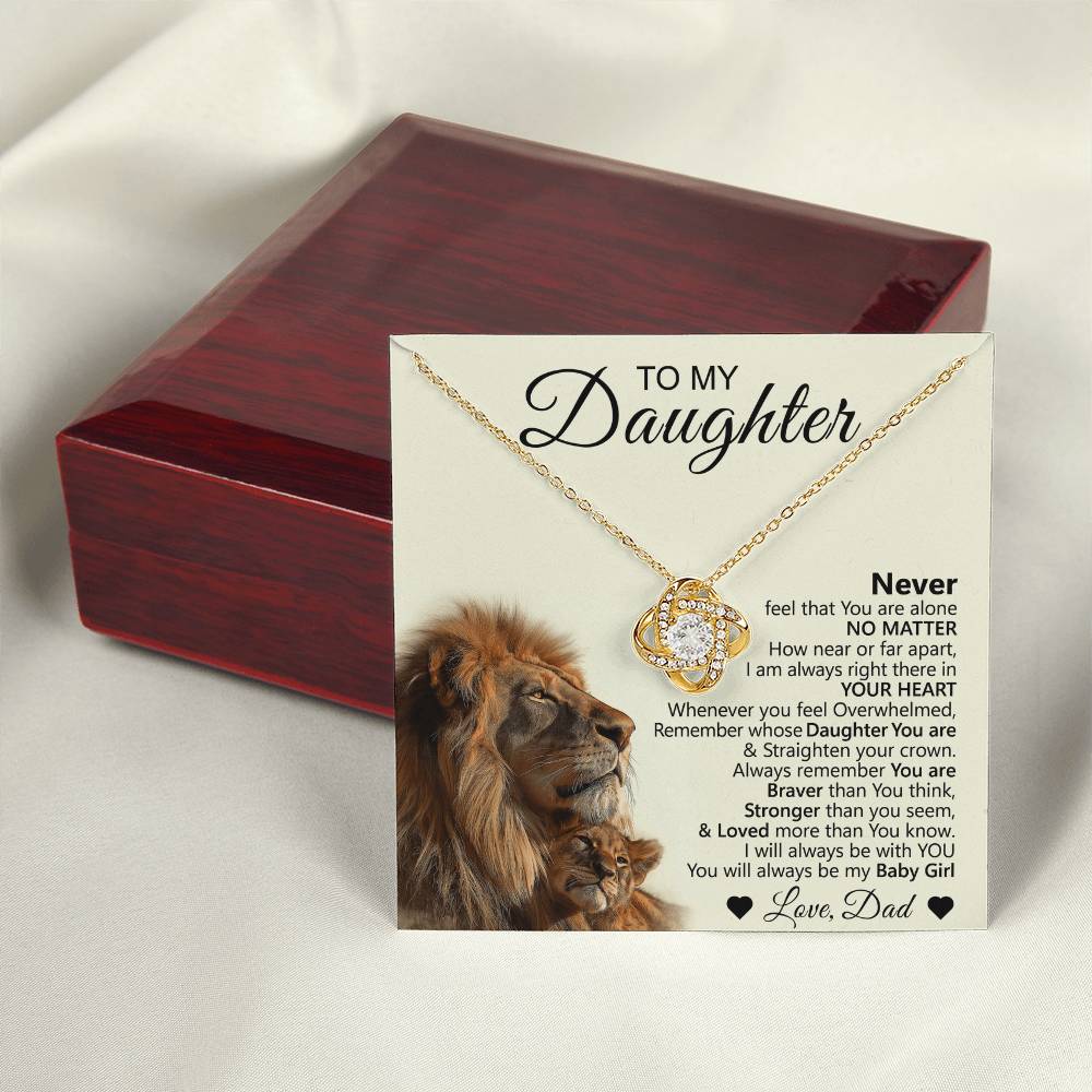 The To My Daughter – Love Knot Necklace comes with a lion & cub message card featuring a heartfelt fathers note and lion image, all elegantly displayed before a polished dark red jewelry box.