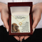 A person holds an open box with the To My Daughter – Love Knot Necklace and a card featuring a lion and cub—an ideal gift expressing love from dad to daughter.