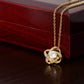 The To My Daughter – Love Knot Necklace features a sparkling central stone encircled by gold loops, beautifully presented on a dark jewelry box with a Lion & Cub message card—an ideal gift for your daughter.