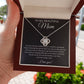 A hand presents an open jewelry box with the To My Beautiful Mom Cubic Zirconia Love Knot Necklace, shown on a black message card featuring an appreciation note and heartfelt I love you!—the perfect Mothers Day or birthday gift.