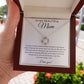 A hand holds an open jewelry box with the To My Beautiful Mom Cubic Zirconia Love Knot Necklace, featuring 14k white gold plating and sparkling crystals, presented on a white message card expressing heartfelt gratitude and love for Mom.