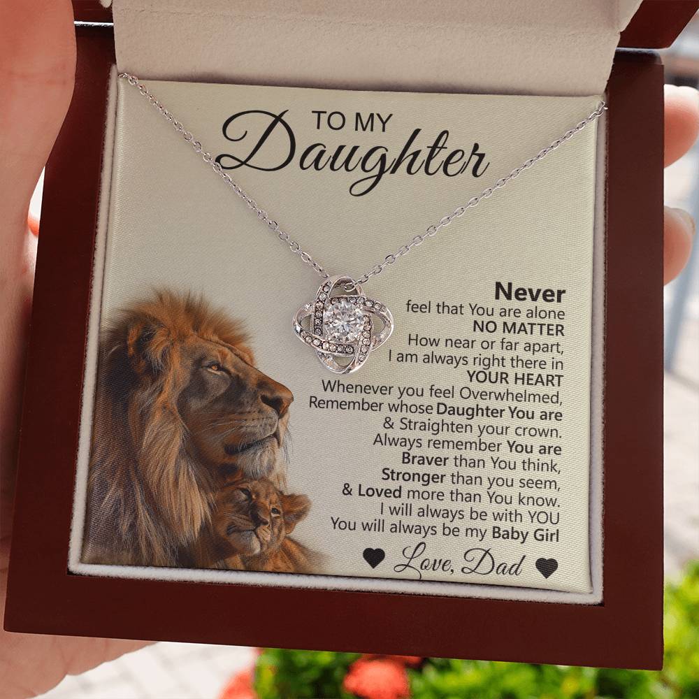 A hand presents the To My Daughter – Love Knot Necklace with Lion & Cub Message Card, featuring a heartfelt note from Dad and an illustration of a lion and cub—an ideal gift to show love and encouragement to your daughter.
