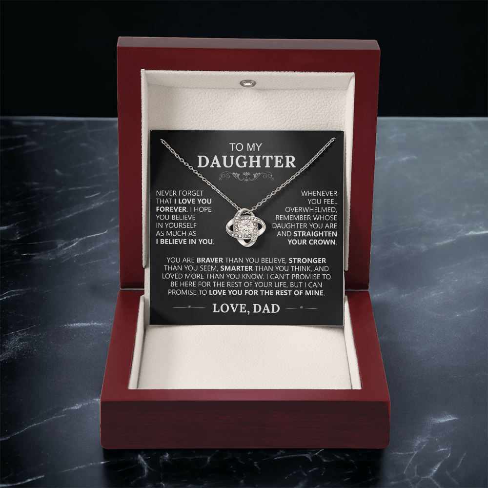 The To My Daughter - Love Knot Necklace features an intertwined pendant in an open wooden box, accompanied by a card titled To My Daughter with an inspiring message about the unbreakable father-daughter bond.