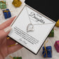 A hand presents the To My Daughter: Forever Connected Message Card & Love Knot Necklace Set, featuring a white gold finish and sparkling cubic zirconia pendant in an open box with a “To my daughter... Love, Dad” note. Colorful gift boxes are in the background.