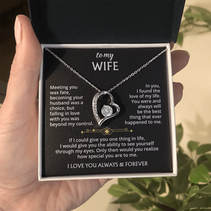 A hand holds an open jewelry box with the To My Wife – Forever Love Necklace with Message of Fate and Devotion inside. The lid features a loving message in white and gold—an unforgettable anniversary gift.