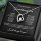 The To My Beautiful Granddaughter - Forever Love Necklace with Heartfelt Message Card features a heart-shaped pendant with a central cubic zirconia, elegantly displayed in a gift box. A loving message offers affection and support, with the gold finish gleaming amidst soft fabric and leafy decoration.