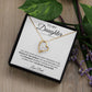 The To My Daughter: Forever Connected Message Card & Love Knot Necklace Set features a gold heart-shaped pendant with a central cubic zirconia, presented in a gift box with a loving message from Dad and surrounded by purple flowers.